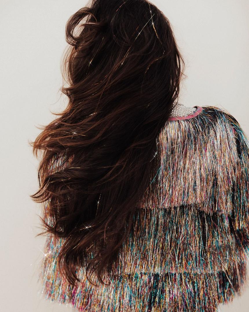 Dark waves from behind, sparkle strands flashing through the length